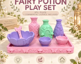 Pode incluir: Um conjunto de brincar de poções de fadas com um tabuleiro retangular rosa com motivos de borboletas e cogumelos, uma taça roxa com uma colher de borboleta, um vaso rosa, um vaso verde com uma porta, um vaso roxo com uma lua e duas taças pequenas.