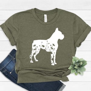 K&ouml;nnte beinhalten: Ein gr&uuml;nes T-Shirt mit einer wei&szlig;en Silhouette eines Boxerhundes, in der Blumen wachsen.