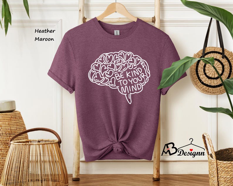 May include: Heather maroon t-shirt with a white outline of a brain made of hearts and the text "Be Kind To Your Mind".