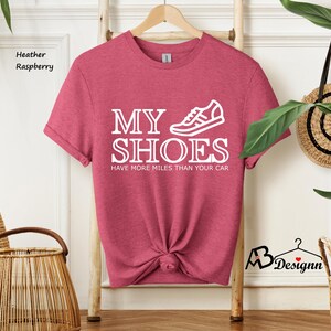 May include: A heather raspberry t-shirt with the text "My Shoes Have More Miles Than Your Car" and a white graphic of a running shoe.