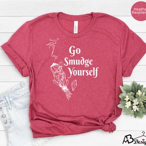 K&ouml;nnte beinhalten: T-Shirt in Heather-Himbeerfarbe mit einem wei&szlig;en Aufdruck eines R&auml;ucherstabs und dem Text "Go Smudge Yourself".