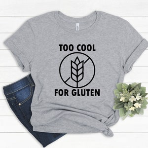 May include: Gray t-shirt with a black graphic that says "Too Cool For Gluten" with a crossed-out wheat symbol.