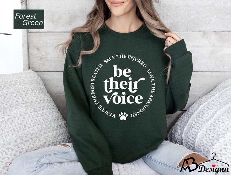 May include: A forest green sweatshirt with a white circle graphic that says "Rescue the mistreated, save the injured, love the abandoned, be their voice".