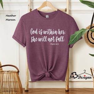 Peut inclure: T-shirt en heather marron avec le texte "Dieu est en elle. Elle ne tombera pas. -Psaume 46:5" imprim&eacute; en blanc.