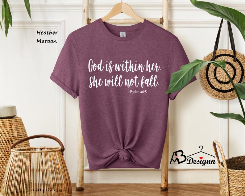 Peut inclure: T-shirt en heather marron avec le texte "Dieu est en elle. Elle ne tombera pas. -Psaume 46:5" imprim&eacute; en blanc.