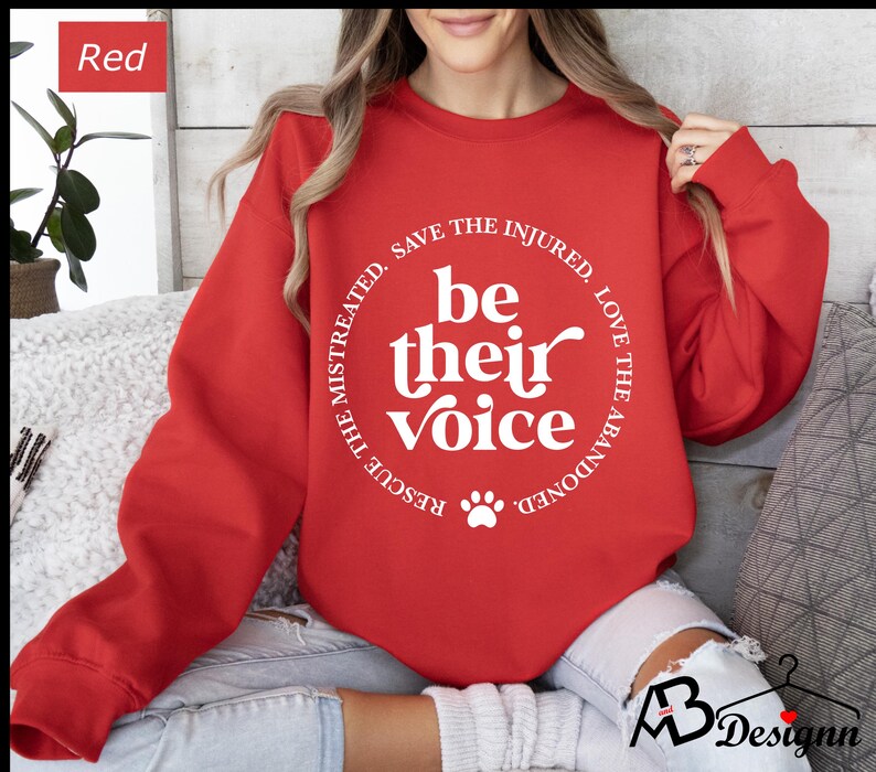 May include: Red sweatshirt with a white paw print and the text "Rescue the mistreated, save the injured, love the abandoned. Be their voice."