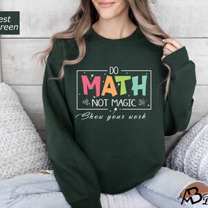May include: Forest green sweatshirt with the text "Do Math Not Magic Show Your Work" in a colorful box.