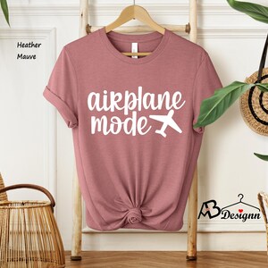May include: A heather mauve t-shirt with the text "airplane mode" in white lettering and a white airplane icon.