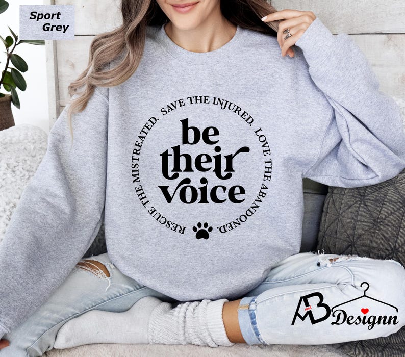 May include: A gray sweatshirt with a black paw print and the text "RESCUE THE MISTREATED. SAVE THE INJURED. LOVE THE ABANDONED. be their voice" printed on the front.