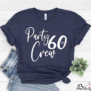 May include: A navy blue t-shirt with white text that says "Party Crew 60" with a small heart symbol next to the number 60.