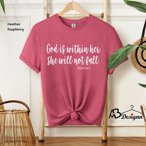 Peut inclure: Un t-shirt en couleur framboise et bruy&egrave;re avec le texte "Dieu est en elle. Elle ne tombera pas. -Psaume 46:5" imprim&eacute; en blanc.