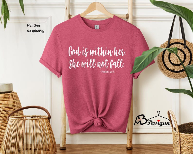Peut inclure: Un t-shirt en couleur framboise et bruy&egrave;re avec le texte "Dieu est en elle. Elle ne tombera pas. -Psaume 46:5" imprim&eacute; en blanc.