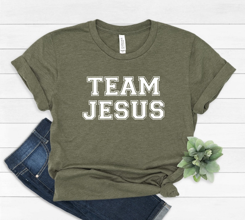 May include: A green t-shirt with the text "TEAM JESUS" in white block letters.