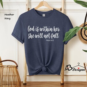 Peut inclure: Un t-shirt bleu marine avec le texte "Dieu est en elle. Elle ne tombera pas. -Psaume 46:5" imprim&eacute; en blanc.