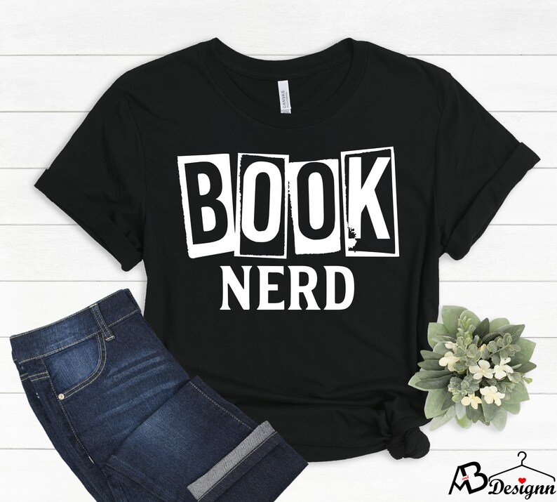 Może przedstawiać: Czarny T-shirt z białym tekstem, kt&oacute;ry brzmi "BOOK NERD" w stylu vintage.