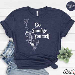 K&ouml;nnte beinhalten: Ein heidefarbenes marineblaues T-Shirt mit einer wei&szlig;en Grafik eines R&auml;ucherstabs und dem Text "Go Smudge Yourself".