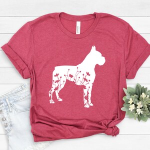 K&ouml;nnte beinhalten: Ein rotes T-Shirt mit einer wei&szlig;en Silhouette eines Boxerhundes mit Blumen in der Silhouette.