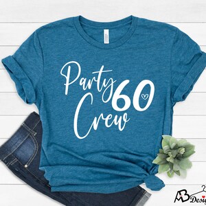 May include: Teal blue t-shirt with white text that says "Party Crew 60" with a small heart next to the number 60.