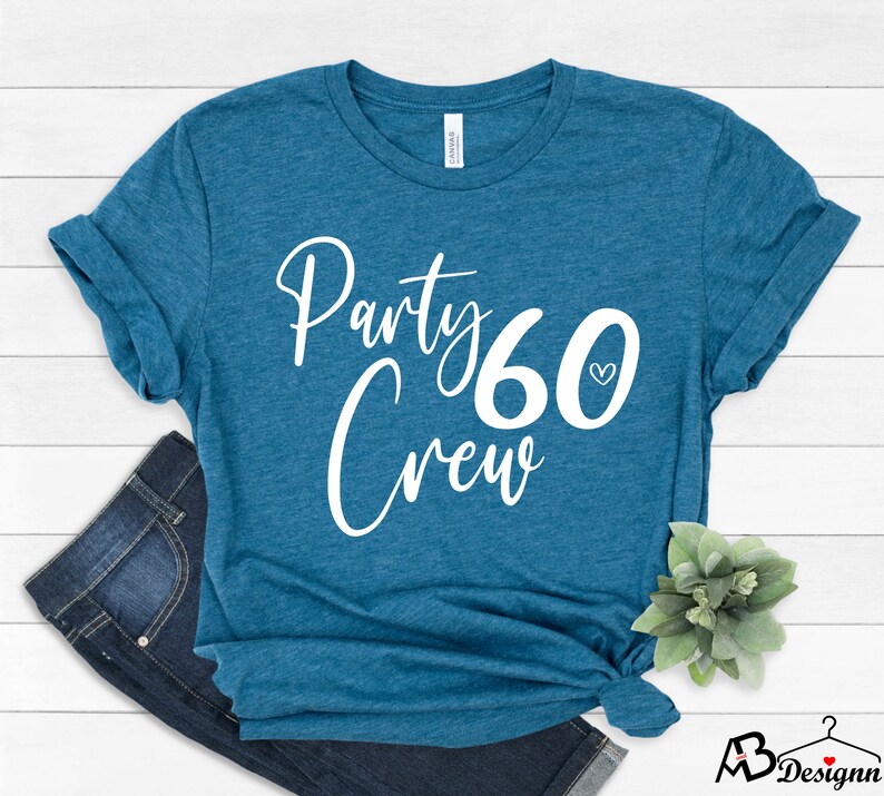 May include: Teal blue t-shirt with white text that says "Party Crew 60" with a small heart next to the number 60.