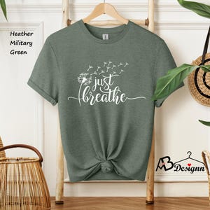 May include: A green t-shirt with a white dandelion design and the text "just breathe".