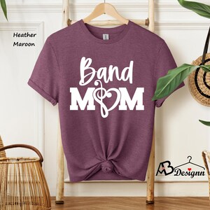 May include: Heather maroon t-shirt with white text that reads "Band Mom" and a musical note and heart graphic.