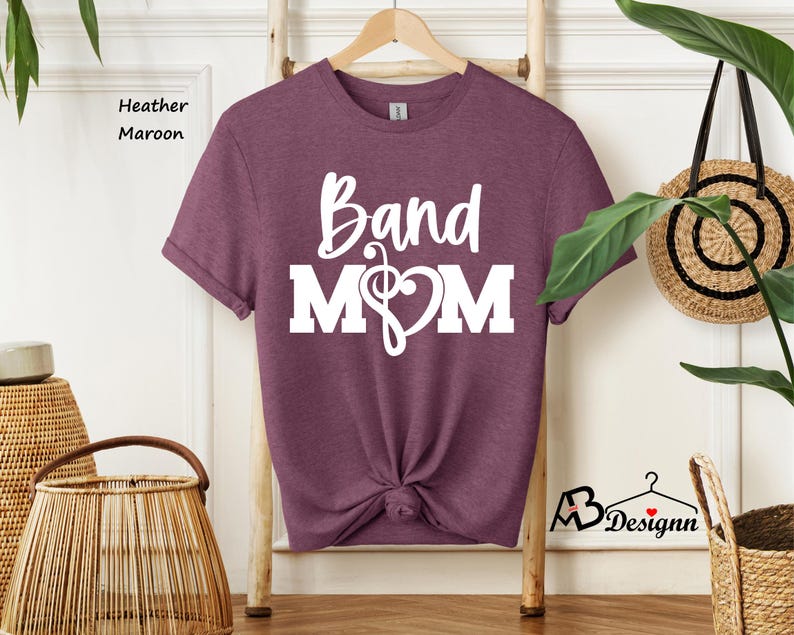 May include: Heather maroon t-shirt with white text that reads "Band Mom" and a musical note and heart graphic.