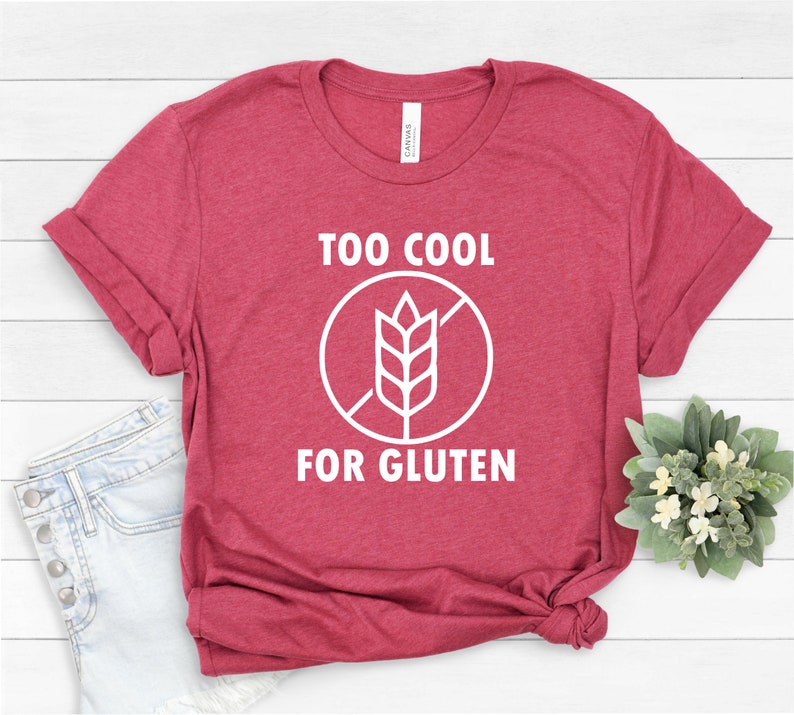 May include: A red t-shirt with white text that reads "Too Cool For Gluten" and a white graphic of a crossed-out wheat stalk.