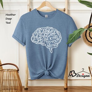 May include: A heather deep teal t-shirt with a white outline of a brain with the text "Be Kind To Your Mind" inside.