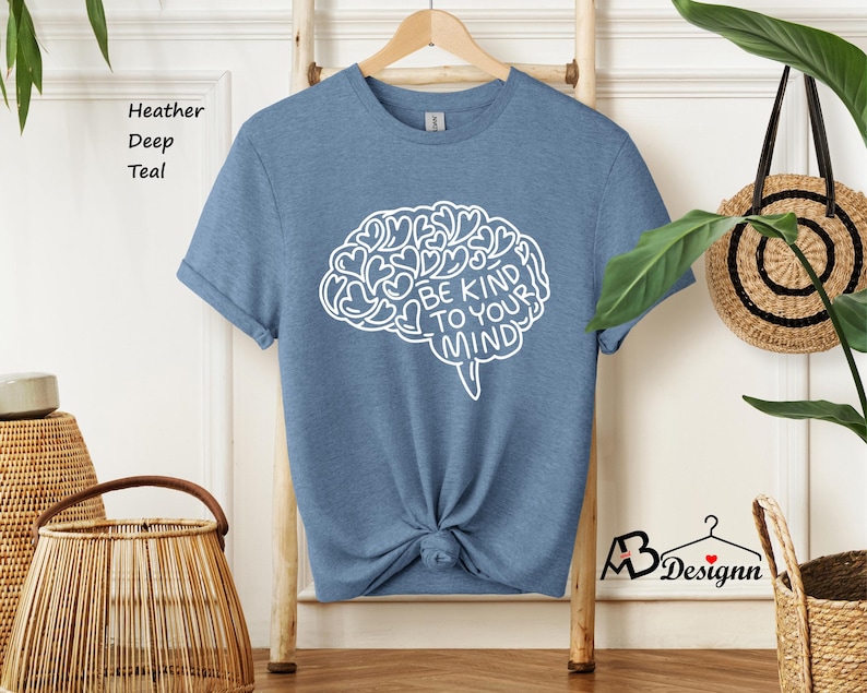 May include: A heather deep teal t-shirt with a white outline of a brain with the text "Be Kind To Your Mind" inside.