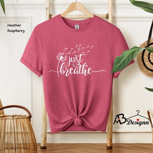 May include: Heather raspberry t-shirt with a white dandelion graphic and the text "just breathe".
