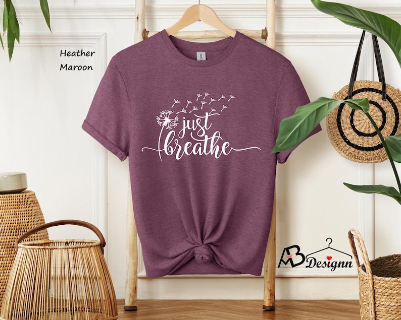 May include: Heather maroon t-shirt with a white dandelion graphic and the text "just breathe".