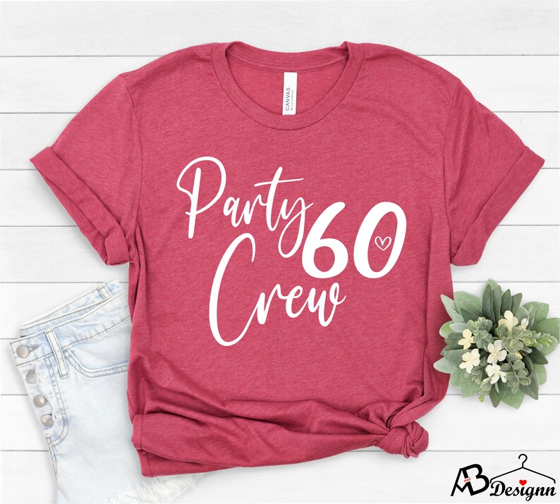 May include: A red t-shirt with white text that says "Party 60 Crew" with a small heart next to the number 60.