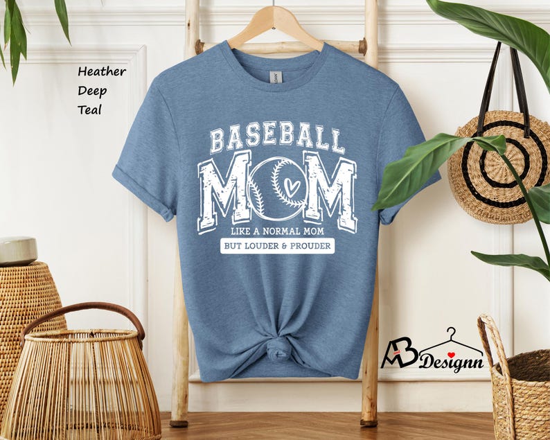 May include: A light blue t-shirt with the text "BASEBALL MOM" in white. The text is surrounded by a baseball graphic and the words "Like a normal mom but louder & prouder".