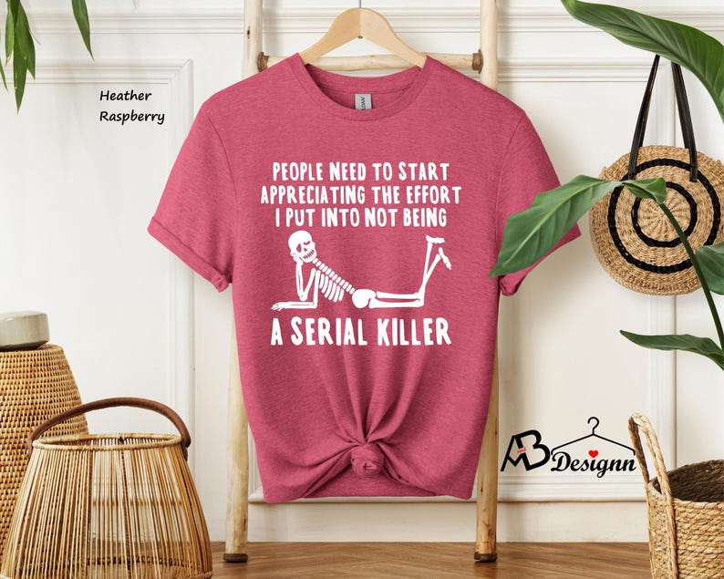 May include: A heather raspberry t-shirt with a white skeleton graphic and the text "People need to start appreciating the effort I put into not being a serial killer".