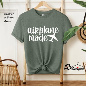 May include: A heather military green t-shirt with the text "airplane mode" in white lettering and a small airplane graphic.