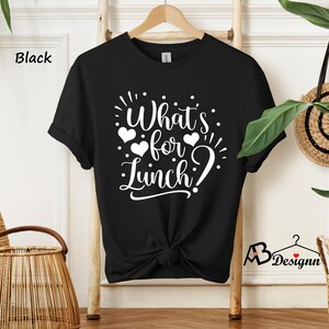 K&ouml;nnte beinhalten: Schwarzes T-Shirt mit wei&szlig;em Text, der "What's for Lunch?" mit Herzen um den Text herum sagt.