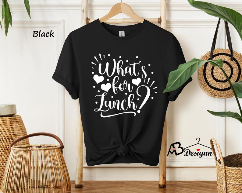 K&ouml;nnte beinhalten: Schwarzes T-Shirt mit wei&szlig;em Text, der "What's for Lunch?" mit Herzen um den Text herum sagt.