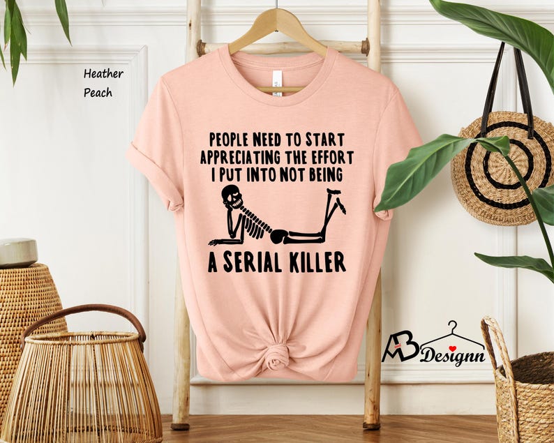 May include: A pink t-shirt with a black skeleton graphic and the text "People need to start appreciating the effort I put into not being a serial killer."