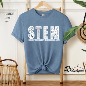 May include: A blue t-shirt with a white graphic that says "STEM" with icons representing science, technology, engineering, and math. The text below the graphic says "SCIENCE TECHNOLOGY ENGINEERING MATH".