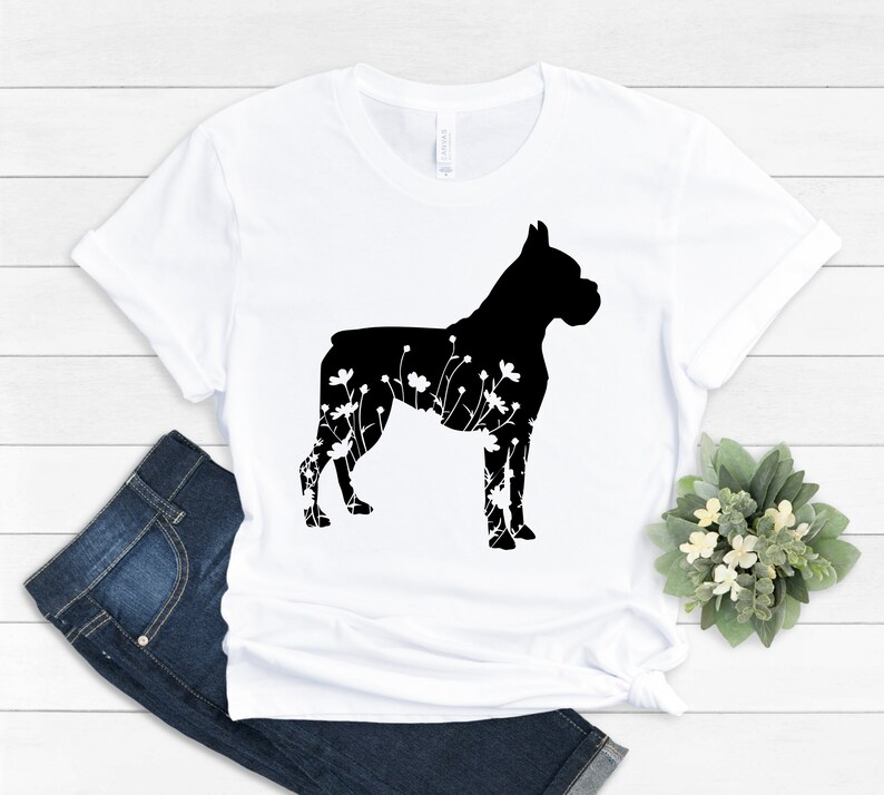 K&ouml;nnte beinhalten: Wei&szlig;es T-Shirt mit einer schwarzen Silhouette eines Boxerhundes mit floralen Details.