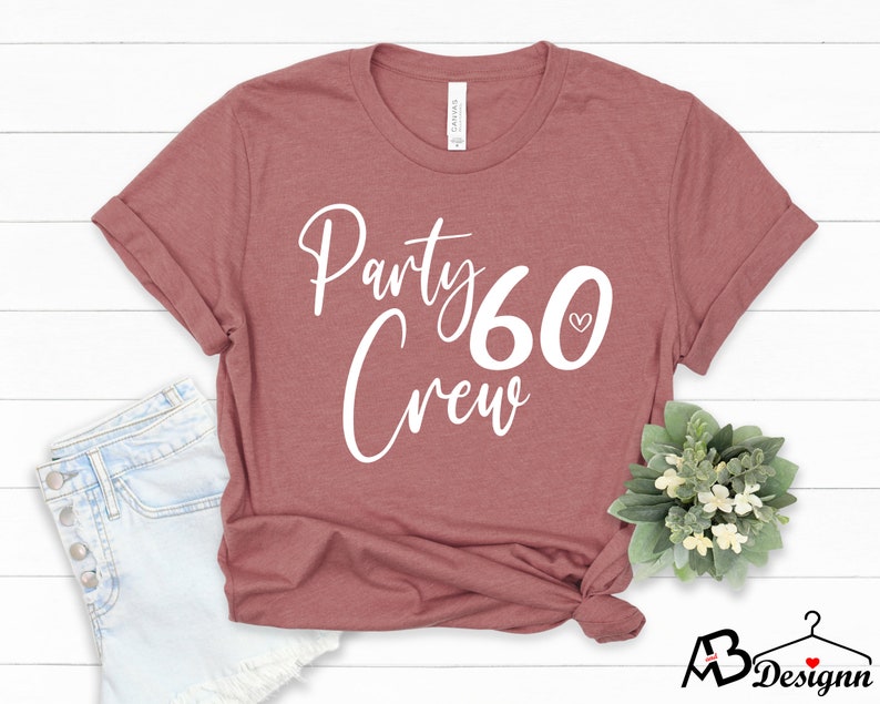 May include: A maroon t-shirt with the text "Party 60 Crew" in white lettering. A small white heart is next to the number 60.