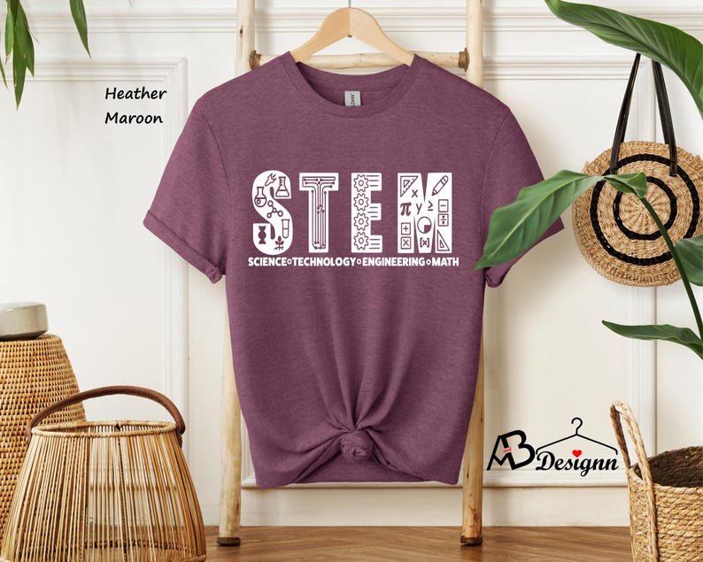 May include: Heather maroon t-shirt with a white graphic of the word "STEM" made up of science, technology, engineering, and math symbols. The text "SCIENCE TECHNOLOGY ENGINEERING MATH" is below the graphic.