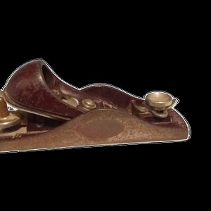 May include: A vintage wooden hand plane with a brown wooden body and a silver metal handle. The plane has a metal blade and a metal adjustment knob.