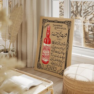 May include: Vintage advertisement poster for Sharbat Rooh Afza, a red beverage. The poster features a bottle of the drink and Urdu text.
