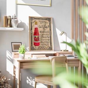 May include: Vintage poster advertising Sharbat Rahafza, a red beverage in a glass bottle. The poster features Urdu text and a decorative border.