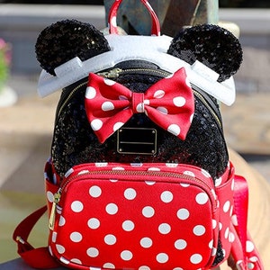 May include: A red and black polka dot backpack with black sequin ears and a red polka dot bow.
