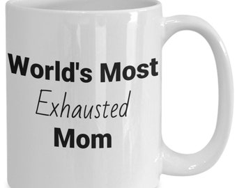Puede incluir: Taza de café de cerámica blanca con texto negro que dice "World's Most Exhausted Mom".