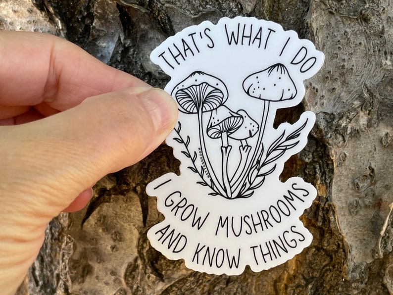 A premium 3 inch by 2 inch die-cut vinyl sticker. The sticker graphic is a black and white cluster of mushrooms with black text. The text says That's What I Do. I Grow Mushrooms And Know Things. Our stickers are waterproof/UV resistant.