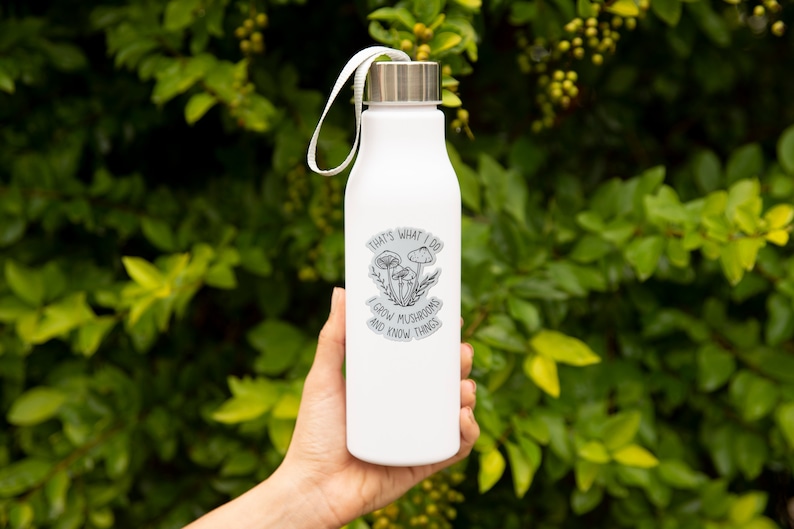 A premium 3 inch by 2 inch die-cut vinyl sticker. The sticker graphic is a black and white cluster of mushrooms with black text. The text says That's What I Do. I Grow Mushrooms And Know Things. Our stickers are waterproof/UV resistant.