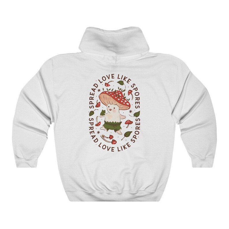 The back of a long-sleeved white color hoodie. It has an art imprint of the colorful mushroom Amanita Muscaria in cartoon form and the words Spread Love Like Spores around the art.